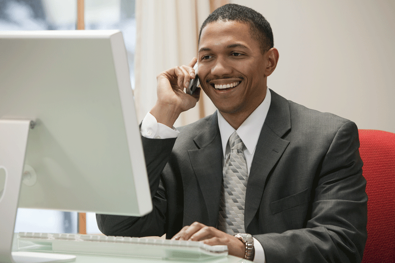 smiling-man-on-phone-and-computer